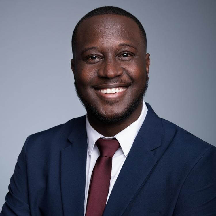 business headshot on light grey background and blue suit